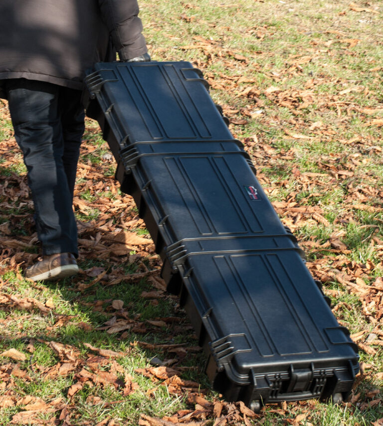 15416 DRAGGING A man transporting a black Explorer 15416 long gun case on the ground.