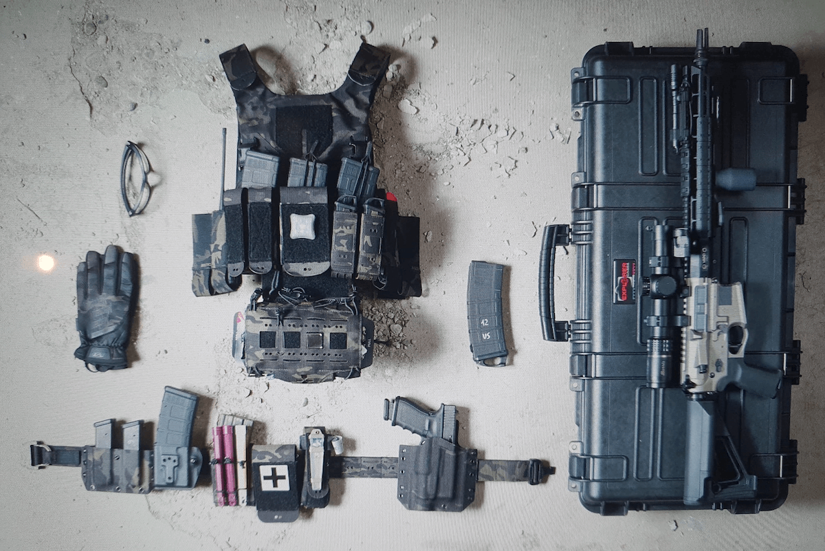 A collection of items from a 7814 survival kit, including a gun and holster, laid out on the floor.