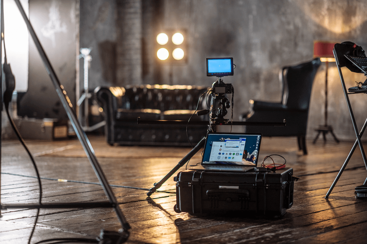 A room features a laptop and camera on a table, alongside an explorer case for exploration activities.